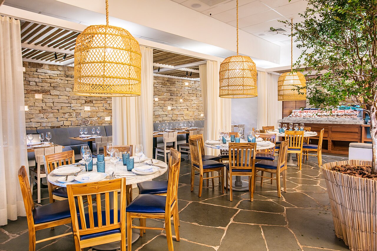 Minimalistyczne wnętrze restauracji z widokiem na kuchnię